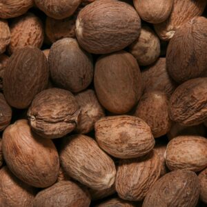 High-quality close-up image of whole nutmeg seeds with textured shells.